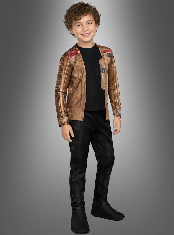 Ein lächelndes Kind mit lockigem Haar, das eine braune Jacke, ein schwarzes Hemd, eine schwarze Hose und schwarze Schuhe trägt, steht vor einem schlichten Hintergrund mit Farbverlauf und präsentiert das Finn-Kinderkostüm – ein Star Wars-Original-Lizenzkostüm.