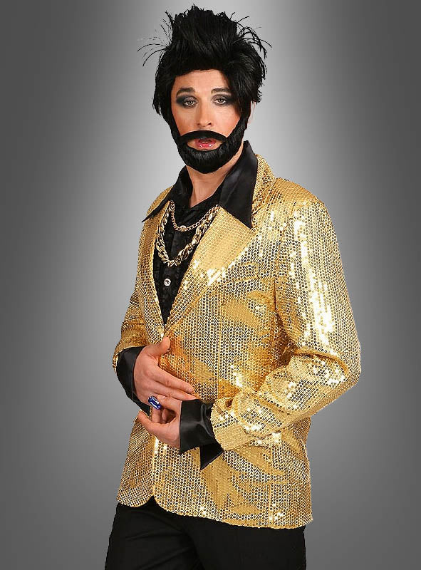 Eine Person, die eine glänzende goldene Paillettenjacke für Herren, ein schwarzes Hemd, mehrere Halsketten, einen künstlichen Bart und eine gestylte schwarze Perücke trägt, steht vor einem grauen Hintergrund mit Farbverlauf – ein auffälliges Karnevalsoutfit, das alle Blicke auf sich zieht.