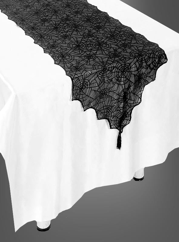 Ein weißer Tisch, geschmückt mit dem Halloween-Tischläufer – einem schwarzen Spitzentischläufer mit Spinnennetz-Muster und gewellten Rändern. Dieser elegante Spinnennetz-Tischläufer eignet sich perfekt als Halloween-Tischdecke und verleiht Ihrer Halloween-Dekoration eine festliche und stilvolle Note.