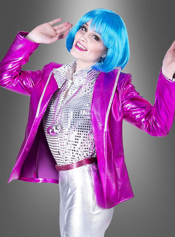 Eine Person mit blauer Perücke, einer Glanzjacke für Damen im Disco-Stil in Metallic-Pink, silberner Hose und einem Paillettenhemd, die lächelnd und mit erhobenen Händen vor einem grauen Hintergrund mit Farbverlauf posiert – eine auffällige Mischung aus Metallic-Look und klassischem Disco-Stil.