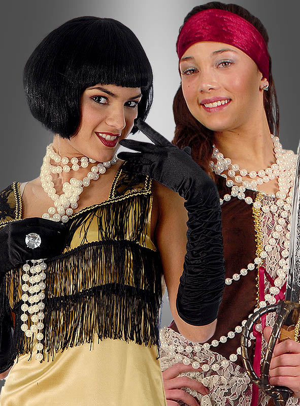 Zwei Frauen in Kostümen: Die eine trägt ein gelbes Flapper-Kleid mit schwarzen Handschuhen und einer „Deluxe Perlenkette Modeschmuck creme“, die andere ist als Piratin verkleidet, mit einem roten Stirnband, mehreren Perlenketten – darunter auch die „Deluxe Perlenkette Modeschmuck creme“ – und hält ein Schwert in der Hand; beide stehen nebeneinander.