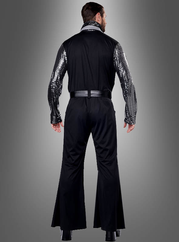 Ein Mann präsentiert den „Silver Star 70er Jahre Overall Herren“ mit glänzenden, silbern gestreiften Ärmeln, während er mit dem Rücken zur Kamera vor einem grauen Hintergrund steht.