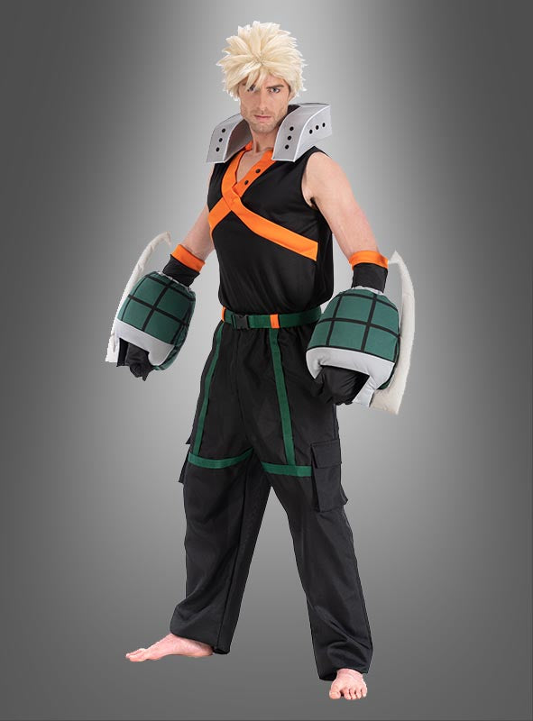 Ein Mann im Katsuki-Bakugo-Kostüm für Erwachsene aus „My Hero Academia“, ideal für Anime-Cosplay für Erwachsene, mit stacheligen blonden Haaren, einem schwarz-orangefarbenen, ärmellosen Oberteil, übergroßen grünen Handschuh-Requisiten und einer schwarzen Cargohose vor grauem Hintergrund.