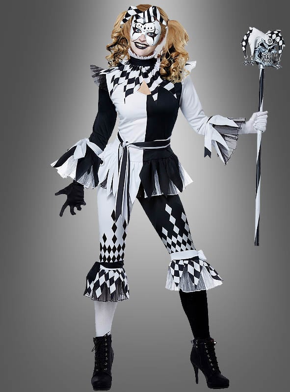 Eine Person, die das „Harlekin Clown für Damen“-Kostüm trägt – mit Rüschenärmeln, einer passenden Maske und einem Narrenstab –, steht vor einem schlichten grauen Hintergrund.