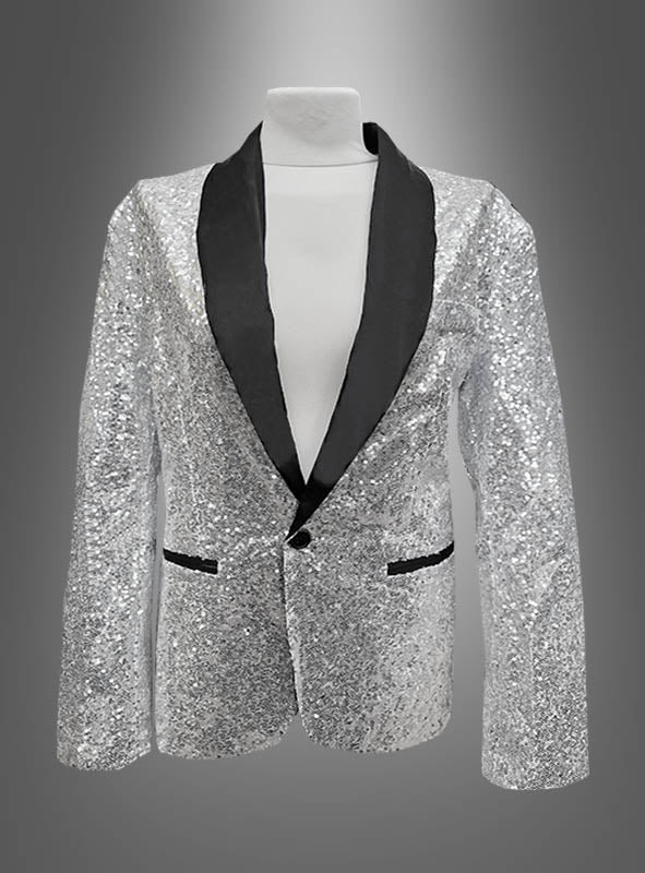 Ein silberner Paillettenblazer mit schwarzem Satinrevers und schwarz eingefassten Taschen, präsentiert auf einem weißen Mannequin-Torso vor einem grauen Hintergrund mit Farbverlauf: Diese „Deluxe Pailletten Jacke“ verkörpert mit ihrem schillernden Pailletten-Finish und den raffinierten Details den Geist einer zeitgenössischen Smokingjacke.