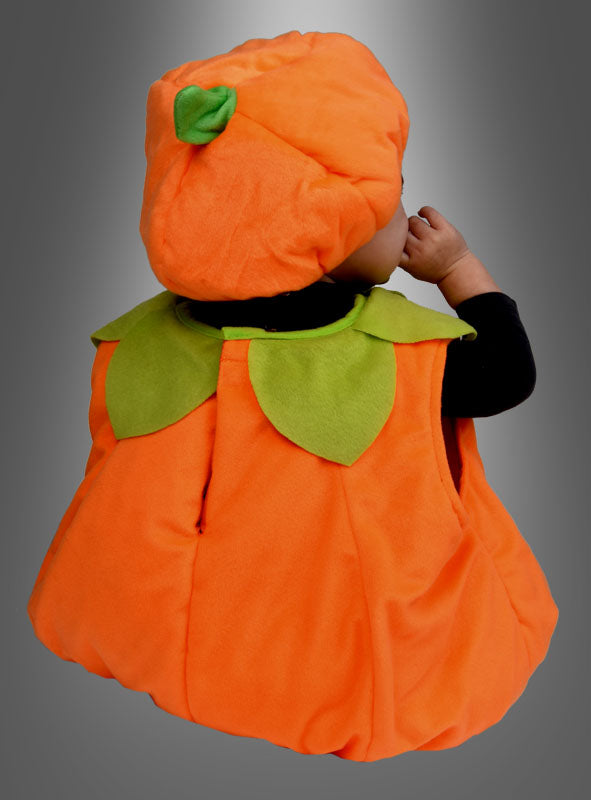 Ein Baby, das das „Süßes Baby-Kürbiskostüm aus wattiertem Plüsch“ mit einem orangefarbenen Körper und einem grünen Hut in Form eines Stiels trägt, sitzt mit dem Rücken zur Kamera vor einem grauen Hintergrund mit Farbverlauf.
