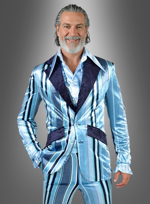 Ein Mann mit grauen Haaren und Bart trägt den 70er-Streifen-Anzug „Olli“ in glänzenden blauen Streifen mit breitem Revers und posiert lächelnd vor einem grauen Hintergrund mit Farbverlauf.