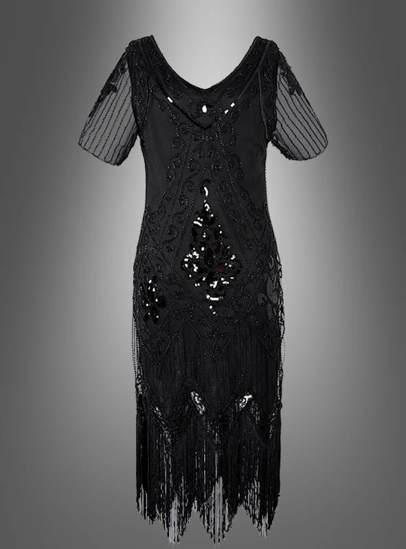Das 20er Paillettenkleid mit transparenten Ärmeln „Gitta“ ist ein schwarzes, knielanges Kleid mit transparenten kurzen Ärmeln, eleganten Perlenverzierungen, funkelnden Pailletten-Details, die an ein klassisches Paillettenkleid für Damen erinnern, sowie verspielten Fransen am Saum, präsentiert vor einem grauen Hintergrund mit Farbverlauf.