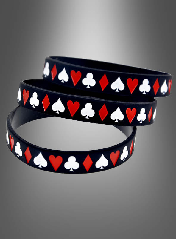 „Casino-Armband schwarz 1 Stück“ ist ein schwarzes Silikonarmband mit roten und weißen Spielkartensymbolen – Herz, Karo, Kreuz und Pik –, die in einem sich wiederholenden Spielkarten-Design auf einem grauen Hintergrund mit Farbverlauf angeordnet sind.