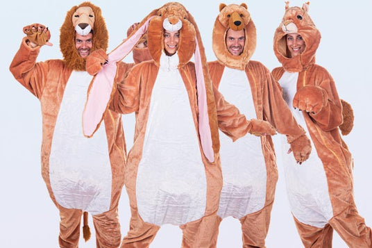 Vier Personen in Tier-Onesies – darunter ein Löwe, ein Hase, ein Bär und ein Eichhörnchen – stehen in einer Reihe und posieren vor einem einfarbigen Hintergrund.