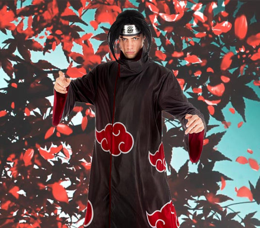 Eine Person in einem schwarz-roten Umhang und einem Stirnband mit Blättern posiert vor einem Hintergrund mit roten Blättern und blauem Himmel.