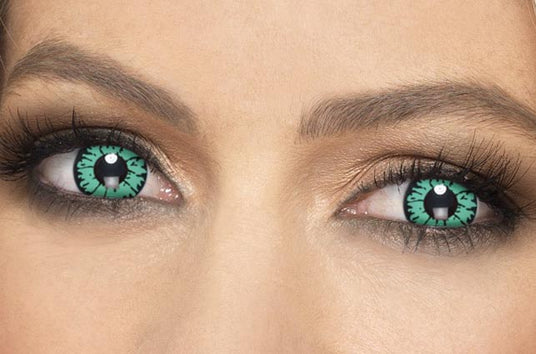 Nahaufnahme des Gesichts einer Person, die grüne Kontaktlinsen mit einem einzigartigen schwarzen Muster in der Iris trägt.
