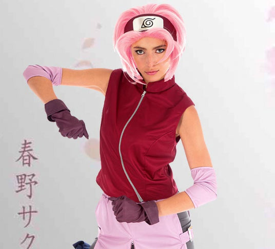 Eine Person mit einer rosa Perücke und einer roten Weste posiert in einem von Naruto inspirierten Kostüm vor einem hellen Hintergrund, auf dem links japanischer Text zu sehen ist.