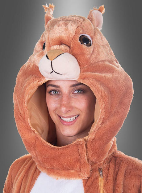 Eine Frau trägt eine weiche, braune Plüsch-Eichhörnchen-Maske mit Schwanz, die waschbar ist und an der Kapuze Ohren sowie ein Eichhörnchengesicht aufweist, das ihr Gesicht vor einem grauen Hintergrund umrahmt.