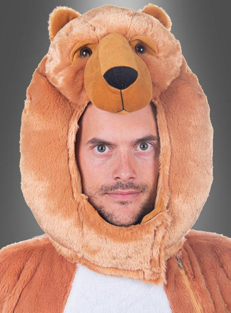 Ein Mann, der den „Plüsch Bär Maskenkopf und Schwanz waschbar“ trägt, wobei die Bärenmaske über seinem eigenen Gesicht sitzt, steht vor einem schlichten grauen Hintergrund – eine verspielte Wahl, die sich ideal für jedes Karnevalskostüm oder jede Plüschtier-Kollektion eignet.