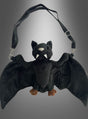 Die Fledermaus-Handtasche aus Plüsch mit schwarzen Flügeln, Stoffzähnen und braunen Füßen wird vor einem grau verlaufenden Hintergrund präsentiert – eine bezaubernde Plüsch-Umhängetasche und das perfekte Kostüm-Accessoire für jedes verspielte Outfit.