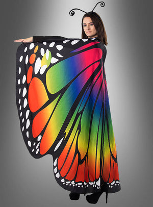 Eine Person in einem Schmetterlingskostüm mit „Deluxe Schmetterlingsflügel“, beidseitig bedruckt, 170 cm, und einem Stirnband mit Fühlerchen, vor einem grauen Hintergrund mit Farbverlauf – perfekt für den Karneval oder alle, die auf der Suche nach stilvollen Schmetterlingsflügeln für Damen sind.