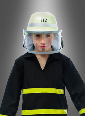 Ein Kind, das einen Feuerwehrhelm mit Visier und eine Uniform trägt und auf dessen Helm die Zahl 112 zu sehen ist, steht stolz vor einem schlichten grauen Hintergrund.