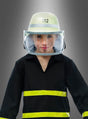 Ein Kind, das einen Feuerwehrhelm mit Visier und eine Uniform trägt und auf dessen Helm die Zahl 112 zu sehen ist, steht stolz vor einem schlichten grauen Hintergrund.