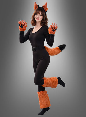 Eine Frau in einem schwarzen Body mit orangefarbenen Fuchsohren, Pfoten, Schwanz und Stulpen aus dem 6-teiligen Tierkostüm-Fuchs-Set aus Plüsch posiert verspielt auf einem Bein vor einem grauen Hintergrund mit Farbverlauf.