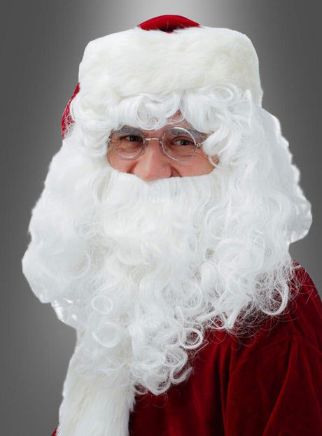 Eine Person mit einer roten Weihnachtsmannmütze und einer Brille, die ein Weihnachtsmannkostüm trägt und mit dem „weißen Bart und der Perücke für den Weihnachtsmann“ ausgestattet ist, steht vor einem grauen Hintergrund.