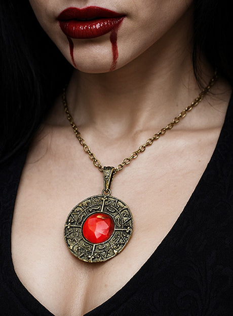 Eine Frau mit dunklem Haar trägt das „Magische Amulett mit rotem Edelstein Vampir“, ergänzt durch roten Lippenstift und Make-up, das an Blut erinnert, das aus ihrem Mund tropft.