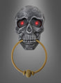Wir präsentieren den Totenkopf-Türklopfer mit Licht und Sound: Ein metallener Totenkopf-Türklopfer mit leuchtend roten Augen und einem goldenen Ring im Mund vor einem grauen Farbverlauf – ideal als gruselige Halloween-Dekoration für ein Spukschloss oder als auffälliger Halloween-Türklopfer, um Ihre Gäste gebührend zu begrüßen.