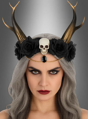 Eine Frau mit langen grauen Haaren trägt das Blumen-Haarband „Dämonin mit Hörnern“, ein Gothic-Haarband mit schwarzen Blumen, Hörnern, einem Totenkopf und einem schwarzen Edelstein. Mit ihrem auffälligen Make-up und ihrem ernsten Gesichtsausdruck vor grauem Hintergrund verkörpert sie einen ätherischen und zugleich kraftvollen Look – damit ist dies das perfekte Halloween-Accessoire für alle, die auf der Suche nach dramatischem Flair sind.