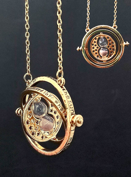 Magischer Zeitumkehrer-Halskette in Gold: Goldene Halskette mit einem Sanduhr-Anhänger in der Mitte und drehbaren Ringen, die aufwendige Muster und eingravierte Schriftzüge aufweisen und vom legendären Hermine-Granger-Zeitumkehrer-Amulett aus Harry Potter inspiriert sind, dargestellt vor schwarzem Hintergrund.