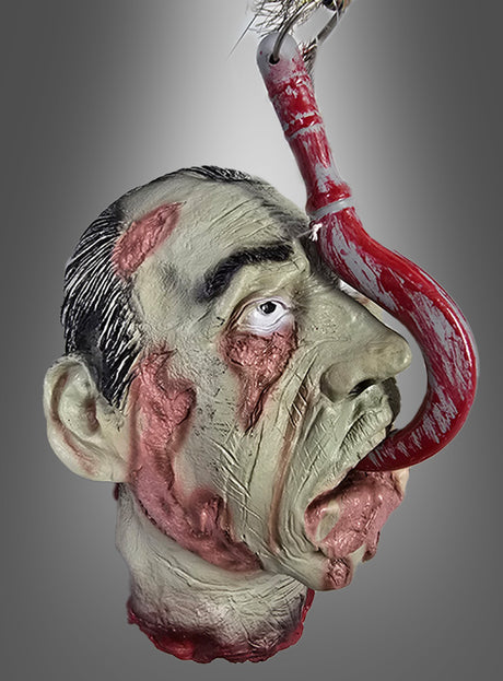 Eine realistische Halloween-Dekoration: Ein Horror-Kopf mit Zunge und verwesender Haut, der auf grausame Weise mit einem großen, blutverschmierten Fleischhaken durch den Mund aufgespießt ist – vor einem grauen Hintergrund mit Farbverlauf. Perfekt als auffällige Dekoration für eine Zombie-Party oder als unvergesslicher Blickfang auf dem Tisch.
