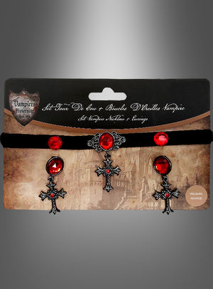 Das Set „Halloween-Schmuck: Kreuze mit roten Edelsteinen“ umfasst ein schwarzes Samt-Halsband, das mit einem roten Edelstein und einem Kreuzanhänger verziert ist, sowie dazu passende Ohrringe mit roten Edelsteinen und Kreuzmotiven. Das Ganze wird in einer Verpackung im Gothic-Stil präsentiert – das ideale Gothic-Schmuckset für Ihr Halloween-Schmuck-Set.