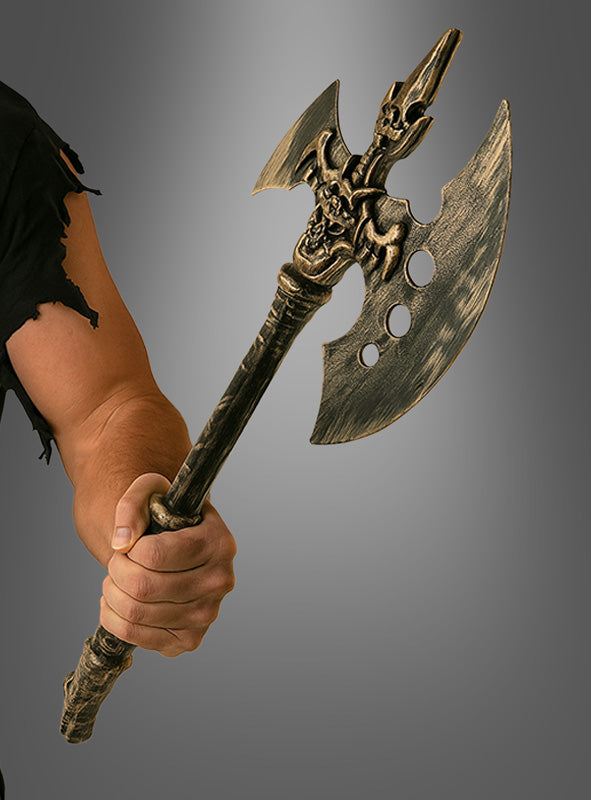 Vor einem grauen Hintergrund hält eine Person die dekorative „Dämonen-Axt Bathomet schwarz-gold 43 cm“ in der Hand, die sich durch kunstvolle Verzierungen und drei Löcher in einer Klinge auszeichnet – eine ideale Halloween-Dekoration oder eine auffällige Fantasy-Waffe für eindrucksvolle Inszenierungen.