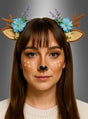 Eine Frau mit glattem braunem Haar trägt das „Rehgeweih-Haarreif mit Ohren“, ein Haarband im Reh-Design mit Geweih, Ohren, Blumen und Lavendel. Ihr Make-up erinnert an ein Rehgesicht mit weißen Flecken und einer schwarzen Nase – damit eignet sich dieser Look perfekt für jedes Reh-Kostüm oder jede Märchenwald-Party.