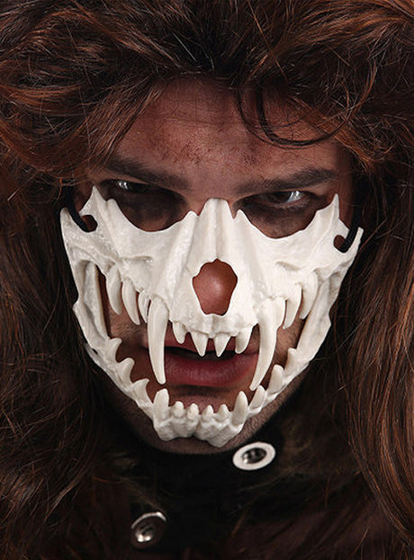 Eine Person, die die „Skelett Gesichtsmaske Reißzähne“ trägt – mit scharfen Reißzähnen und langen braunen Haaren –, blickt mit eindringlichem Blick direkt in die Kamera.