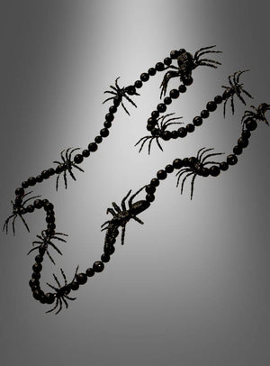 Eine schwarze Spinnengirlande (160 cm) mit schwarzen Perlen und mehreren schwarzen Plastikspinnen, ideal als Spinnendekoration oder Halloween-Dekoration, vor einem grauen Hintergrund mit Farbverlauf.