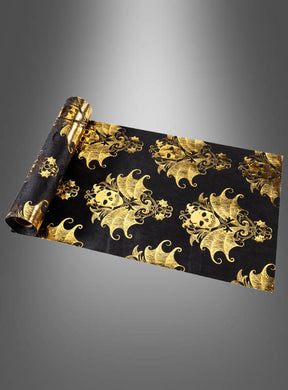 Luxuriöser Samt-Tischläufer, 3 m lang, im Barockstil mit Totenkopf in Schwarz, verziert mit einem kunstvollen, sich wiederholenden goldenen Totenkopf- und Fledermausmotiv im Barockstil – ideal für eine stilvolle Halloween-Tischdekoration – auf einem grau verlaufenden Hintergrund.