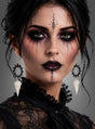 Eine Frau mit auffälligem Make-up um Augen und Lippen, die ein Spitzenoberteil trägt und deren schwarzes Haar hochgesteckt ist, blickt direkt in die Kamera. Abgerundet wird ihr Look durch „Skelett Ohrringe Krähe“ – Ohrringe in Form eines Krähen-Schädels.
