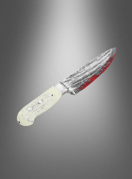 Ein gezacktes „Blutiges Küchenmesser“ (33 cm) mit einem abgenutzten, hellen Griff und einer teilweise rot befleckten Klinge wird vor einem grauen Hintergrund mit Farbverlauf präsentiert und ist damit die perfekte Ergänzung für jedes Horror-Kostüm oder ein gruseliges Horror-Accessoire.