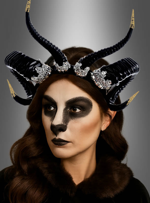 Frau mit schwarz-weißer Gesichtsbemalung, schwarzem Lippenstift und einem großen Gothic-Kopfschmuck mit den „Geschmückten Hörnern schwarz-silber“, die auf grauem Hintergrund mit Kristallen verziert sind.