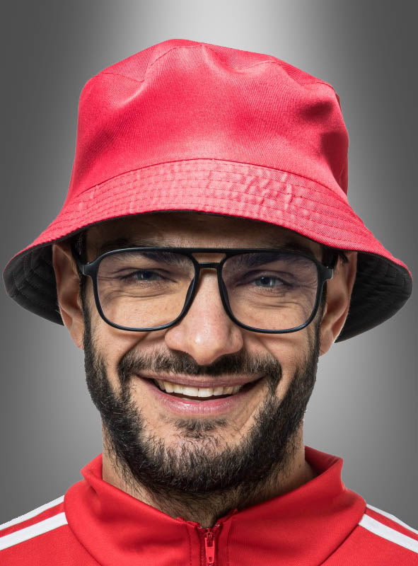 Ein Mann mit Bart und Brille trägt einen roten „Wandelbarer 2-in-1-Eimerhut mit Brille“ und eine dazu passende rote Jacke und lächelt vor einem grauen Hintergrund mit Farbverlauf – eine verspielte Anspielung auf den Karneval und den klassischen Outfit-Stil der 90er Jahre.