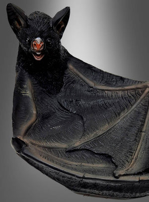 Eine Nahaufnahme der „Deluxe Fledermaus Schale 24 cm aus Kunstharz“ zeigt eine auffällige schwarze Fledermaus mit ausgebreiteten Flügeln und gefletschten Zähnen vor einem grauen Hintergrund mit Farbverlauf – perfekt, um Ihrer Halloween-Dekoration einen geheimnisvollen Touch zu verleihen oder als faszinierender Blickfang in Ihrer gotischen Tischdekoration.