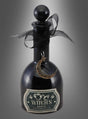 Eine schwarze Glasflasche mit der Aufschrift „Witch’s Brew“, einem runden Stopfen, einem schwarzen Band und einem Halbmond-Anhänger – die „Hexentrank“-Flasche (8 x 19 cm) ist die perfekte Halloween-Dekoration vor einem grauen Hintergrund mit Farbverlauf.
