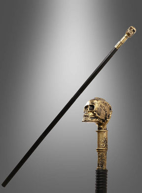 Ein schwarzer Gehstock, der „Gehstock 105 cm extra lang Totenkopf gold“, wird mit einem detailreich gearbeiteten goldenen Totenkopfgriff mit kunstvollen Gravuren gezeigt – damit ist er das perfekte Halloween-Kostümzubehör.