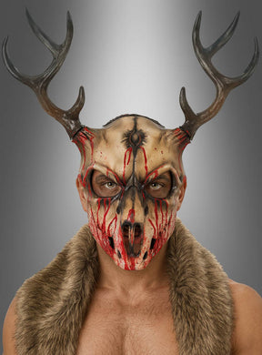 Eine Person, die die „Blutiger Hirsch Skelett-Maske“ trägt – entworfen im Stil einer Schaumstoff-Tierschädelmaske mit markantem Geweih und realistisch wirkendem Kunstblut –, steht in einer Pelzweste vor einem neutralen Hintergrund und blickt nach vorne. Diese unverwechselbare Halloween-Verkleidung strahlt eine unheimliche, unvergessliche Präsenz aus.