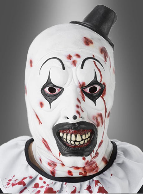 Person, die die „Blutige Terrifier Maske“ (Halloween-Horrorclown) trägt – eine weiße, mit Blutspritzern übersäte Maske mit schwarzen Make-up-Details, bedrohlichen, scharfen Zähnen und einem kleinen schwarzen Hut –, die einen gruseligen Look erzeugt, der perfekt für jeden Horrorfan ist.