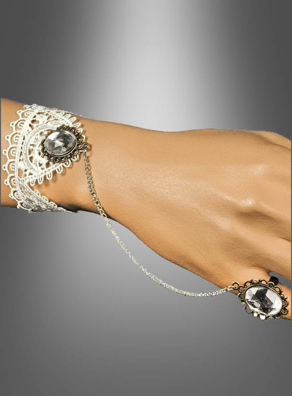 Eine Hand, geschmückt mit dem Steampunk-Handschmuck-Set mit Spitze, bestehend aus einem auffälligen Edelsteinarmband, das über eine zarte Kette mit einem passenden Edelsteinring verbunden ist, präsentiert vor einem grauen Hintergrund mit Farbverlauf – ein exquisites Accessoire, das jedes Steampunk-Outfit aufwertet oder Ihren Look abrundet.