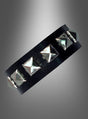 Ein schwarzes Lederarmband mit gleichmäßig verteilten silbernen Pyramidennieten, präsentiert vor einem grau verlaufenden Hintergrund – dieses Nietenarmband „Rocker Punk“ ist der perfekte 80er-Jahre-Schmuck und ein auffälliges Punk-Accessoire für jeden gewagten Look.