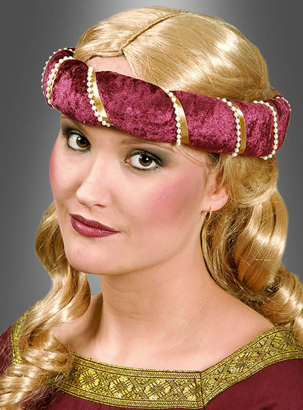 Eine Frau mit langen, blonden Haaren in lockeren Locken trägt ein burgunderrotes Kleid im mittelalterlichen Stil und ein dazu passendes, mit Perlen umwickeltes Stirnband mit der Aufschrift „Jungfernkranz Mittelalter“ und posiert vor einem grauen Hintergrund.