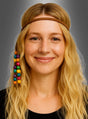 Eine Frau mit langen blonden Haaren, die vor einem grauen Hintergrund in die Kamera lächelt, trägt ein braunes Hippie-Stirnband mit Holzperlen, das auf einer Seite mit bunten Perlen verziert ist.