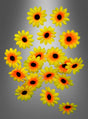 Siebzehn Deko-Blüten in Form von Sonnenblumen mit dunklen Blütenkernen sind vor einem grauen Hintergrund mit Farbverlauf angeordnet und eignen sich daher perfekt, um jeden Raum aufzuhellen oder Ihrer Hippieparty-Dekoration eine fröhliche Note zu verleihen.